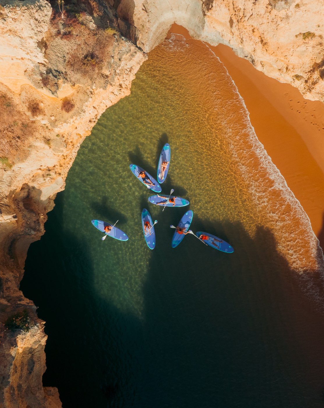 Aerial view of paddlers fanned out in an Algarve cove