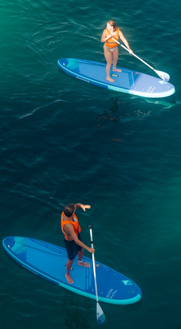 Aerial view of two paddlers on SUP boards in turquoise water