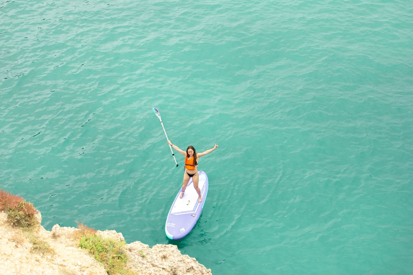 Solo paddler at sunrise Algarve cliffs